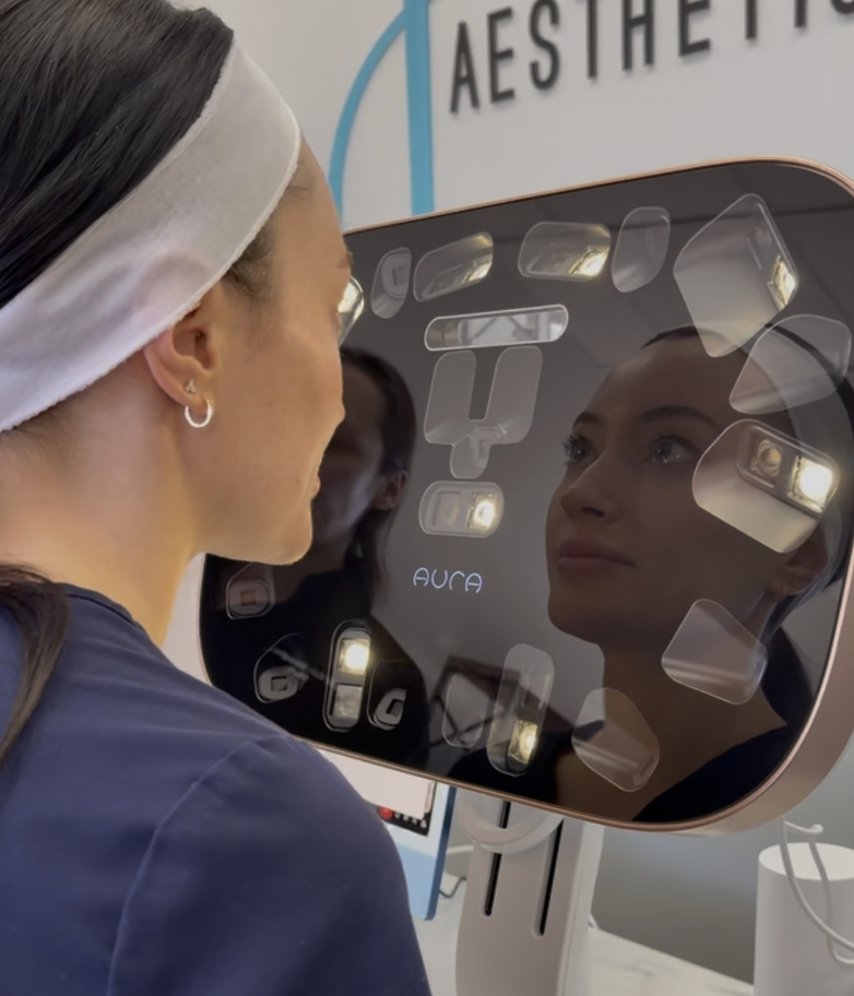 Client viewing her face in the AURA 3D facial scanning mirror at Juvly Aesthetics