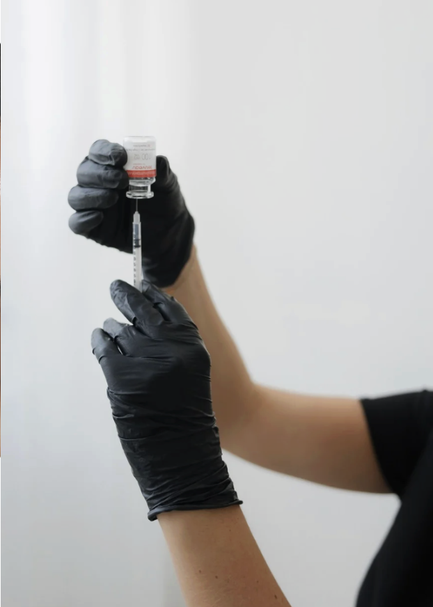 Juvly Aesthetics provider in black gloves drawing a wrinkle relaxer into a syringe