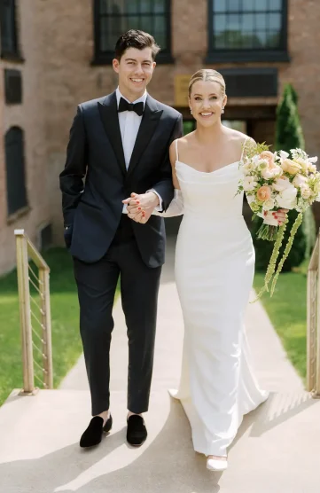 Newlyweds walking hand in hand outside their venue