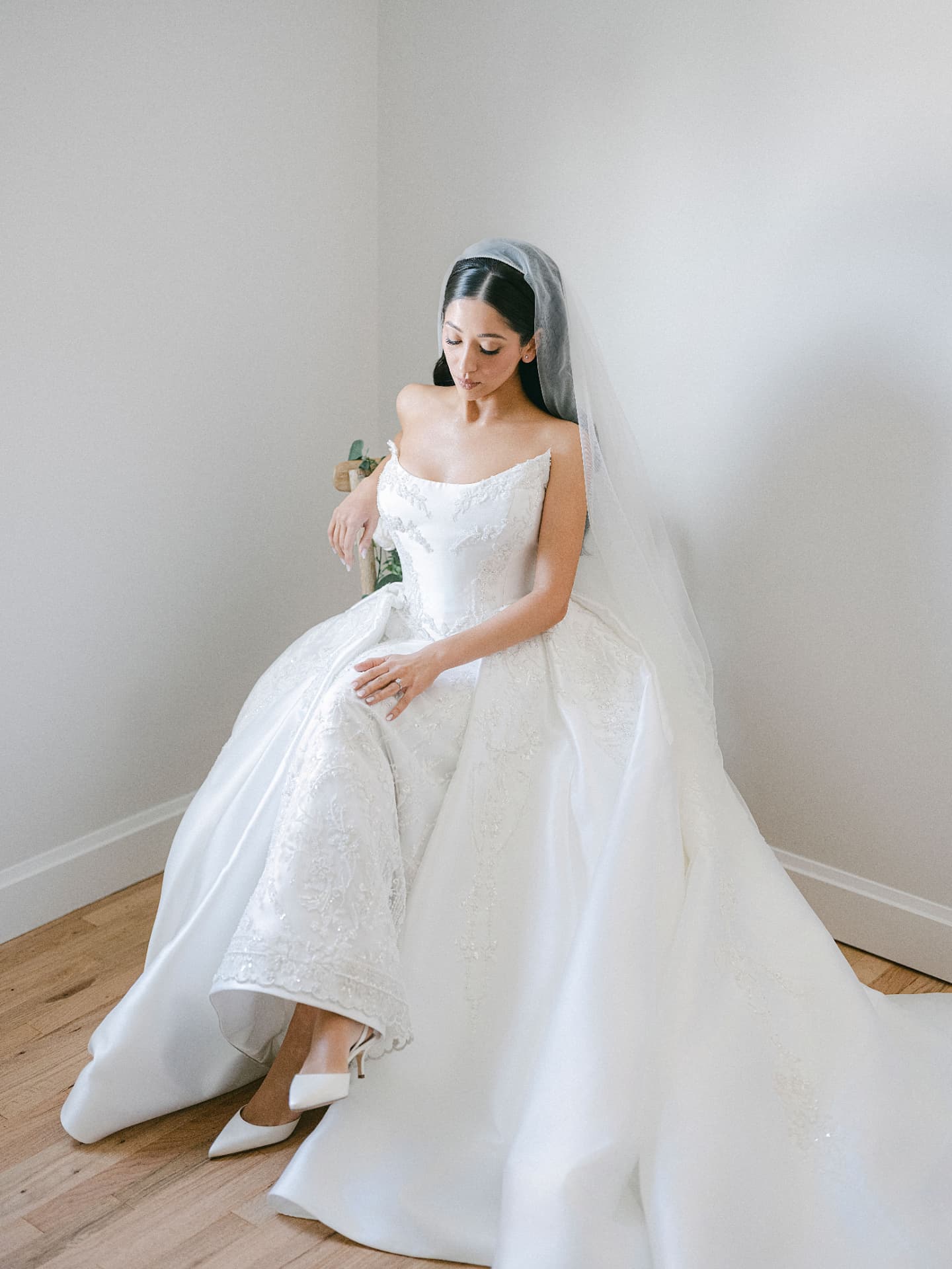 Bride seated in a cathedral veil and beaded gown