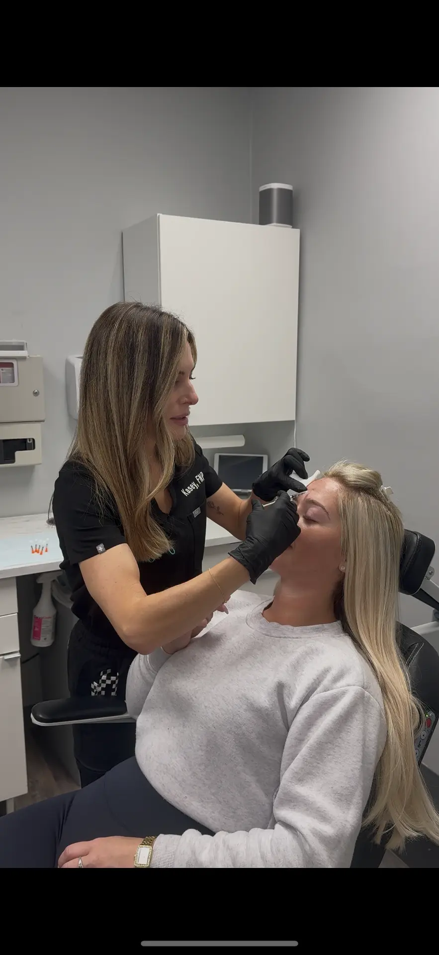 Juvly Aesthetics injector treating a client's forehead with a wrinkle relaxer