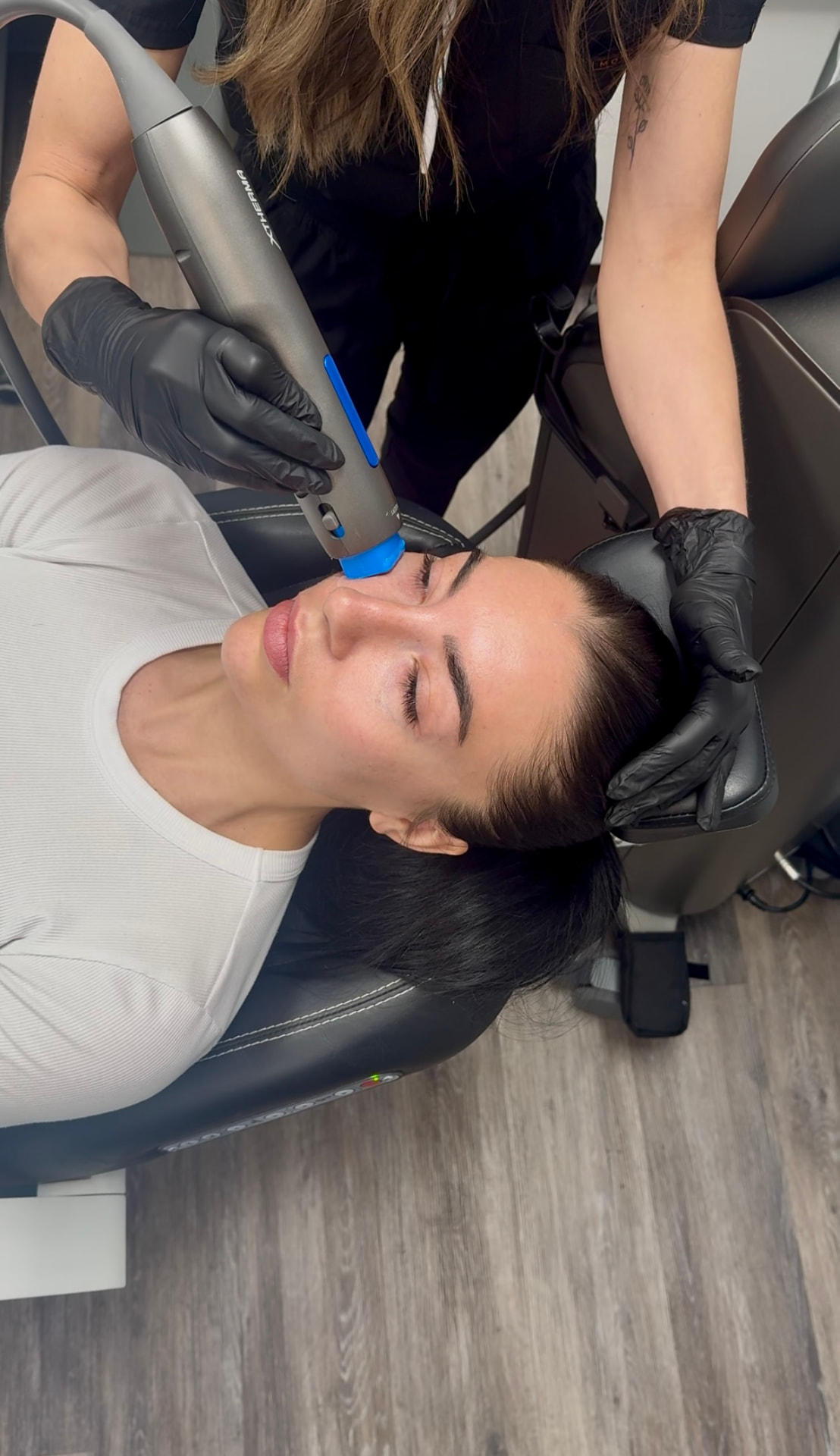 Provider treating a client's jawline with the XTherma handpiece