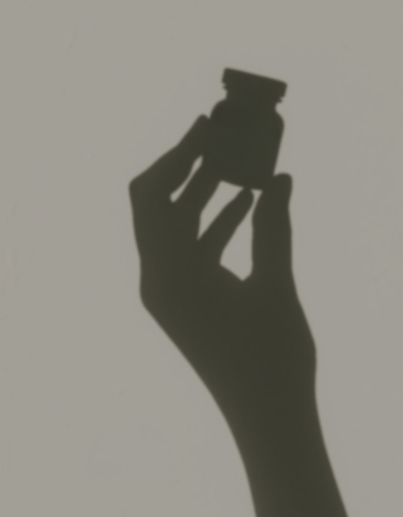 Silhouette of a hand holding an NAD+ vial