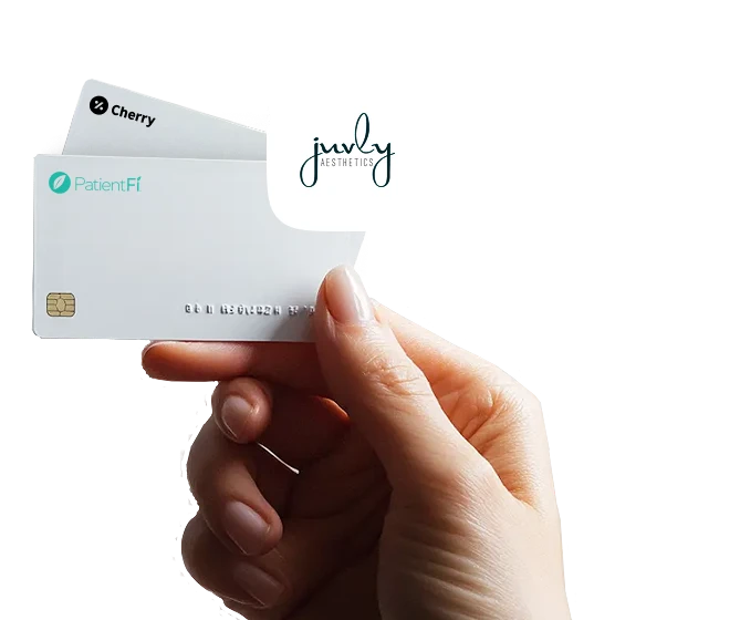 Hand holding Cherry and PatientFi financing cards with the Juvly Aesthetics logo